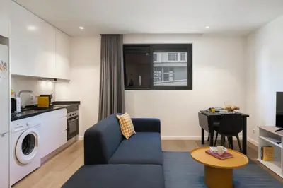 a living room with a blue couch and a table at Golden City by An Island Apart in Funchal