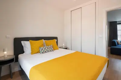 a bedroom with a large bed with yellow sheets at Golden City by An Island Apart in Funchal