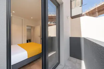 a bedroom with a bed and a sliding glass door at Golden City by An Island Apart in Funchal