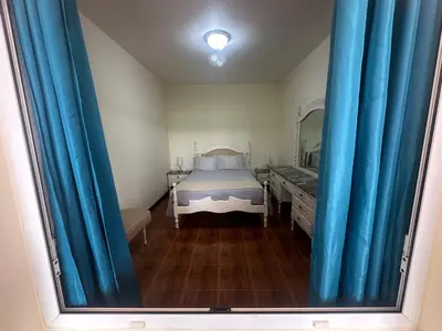 a bedroom with blue curtains and a bed with a mirror at Elisabeth House in Ponta do Sol