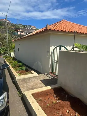 a white house with a gate and a driveway at Elisabeth House in Ponta do Sol