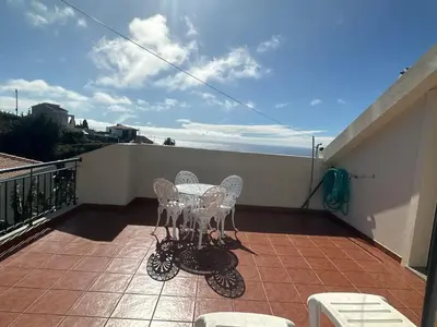 a patio with a table and chairs on a balcony at Elisabeth House in Ponta do Sol