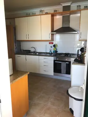 a kitchen with white cabinets and a stove top oven at Villa das Acacias Praia da Luz beautiful 3 bedroom villa with sea views in Luz