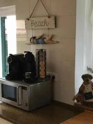 a kitchen with a microwave and a sign that reads beach at Villa das Acacias Praia da Luz beautiful 3 bedroom villa with sea views in Luz