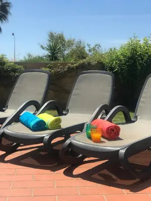 two chairs with colorful back cushions on a patio at Villa das Acacias Praia da Luz beautiful 3 bedroom villa with sea views in Luz