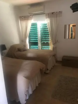 two beds in a room with a window at Villa das Acacias Praia da Luz beautiful 3 bedroom villa with sea views in Luz