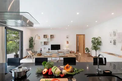 a kitchen and living room with a table with vegetables on a counter at Germana House by An Island Apart in Ponta do Sol