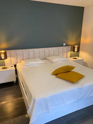 a large white bed with yellow pillows on it at B&B Camacha Porto Santo in Porto Santo