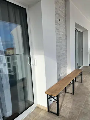 a wooden bench sitting on the side of a building at Villa Supranee Paradise in Câmara de Lobos