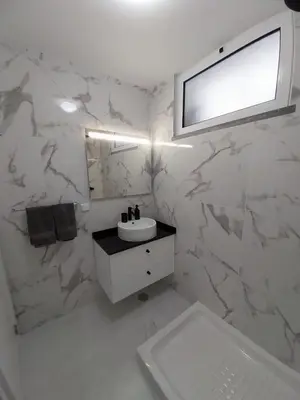 a white bathroom with a sink and a mirror at Villa Supranee Paradise in Câmara de Lobos