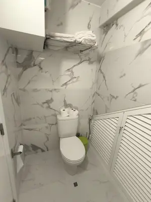 a bathroom with a toilet and marble walls at Villa Supranee Paradise in Câmara de Lobos