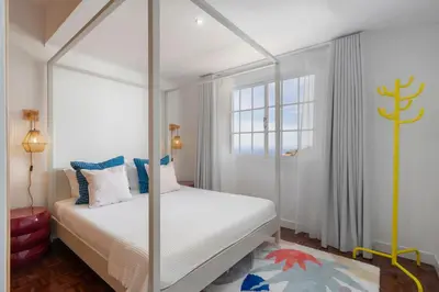 a bedroom with a canopy bed and a window at Casa das Maravilhas by An Island Apart in Câmara de Lobos