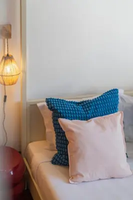 a bed with blue and white pillows and a lamp at Casa das Maravilhas by An Island Apart in Câmara de Lobos