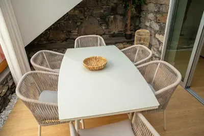 a white table and chairs with a basket on top at HOMELIKE FUNCHAL I in Funchal