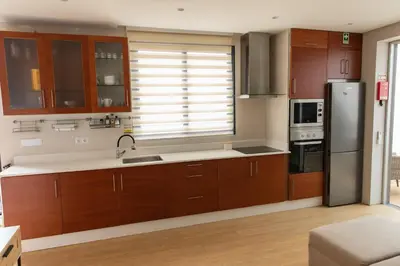 a kitchen with wooden cabinets and a stainless steel refrigerator at HOMELIKE FUNCHAL I in Funchal