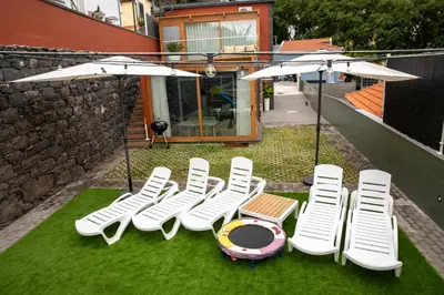a group of chairs and umbrellas on the grass at HOMELIKE FUNCHAL I in Funchal