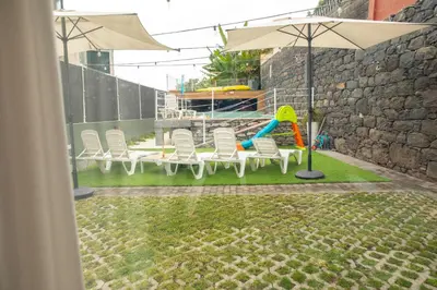 a group of chairs and a playground with an umbrella at HOMELIKE FUNCHAL I in Funchal
