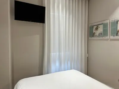 a bedroom with a bed and a flat screen tv at HOMELIKE FUNCHAL II in Funchal