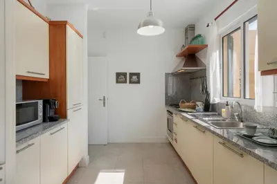 a kitchen with white cabinets and a sink at Casa de Férias by An Island Apart in Porto Santo