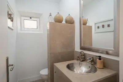 a bathroom with a sink and a toilet and a mirror at Casa de Férias by An Island Apart in Porto Santo