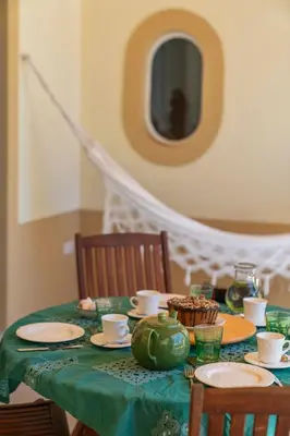 a table with a green table cloth with plates and cups at Casa de Férias by An Island Apart in Porto Santo