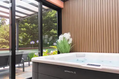 a bath tub in a room with a large window at Casa Requinte - Jacuzzi in Arco da Calheta