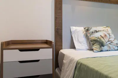 a room with a bed with a night stand next to it at Casa Requinte - Jacuzzi in Arco da Calheta