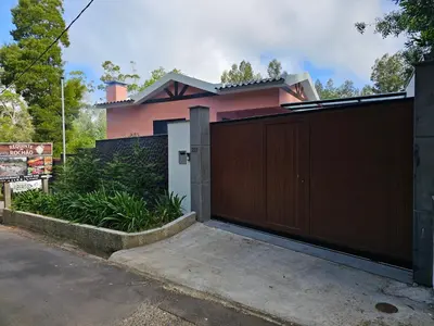 a pink house with a wooden gate at Casa Requinte - Jacuzzi in Arco da Calheta