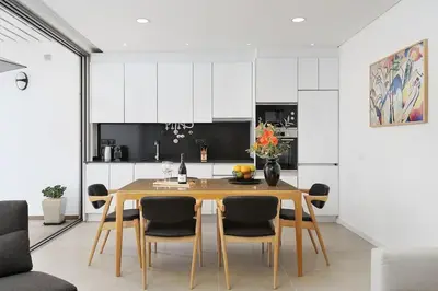 a kitchen and dining room with a wooden table and chairs at Dália modern apartment Five minutes to beach in Luz