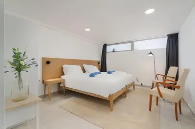 a bedroom with a bed and a desk and a chair at Dália modern apartment Five minutes to beach in Luz