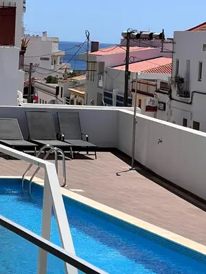 a balcony with chairs and a swimming pool on a building at Dália modern apartment Five minutes to beach in Luz