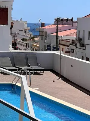 a balcony with chairs and a swimming pool on a building at Dália modern apartment Five minutes to beach in Luz