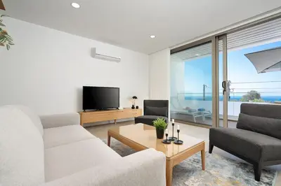 a living room with a couch and a tv at Hibisco is a modern apartment, 5min walk to beach in Luz
