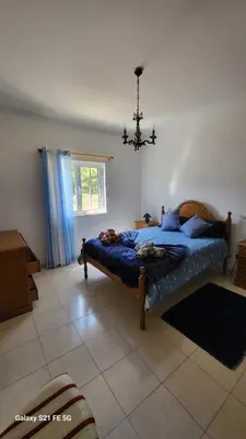a bedroom with a bed and a chandelier at Casa Estêvão in Aljezur