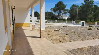 a building with a yard with some animals on the ground at Casa Estêvão in Aljezur
