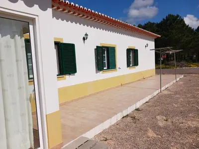 a white building with green shutters on it at Casa Estêvão in Aljezur