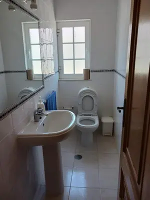 a bathroom with a sink and a toilet and a mirror at Casa Estêvão in Aljezur