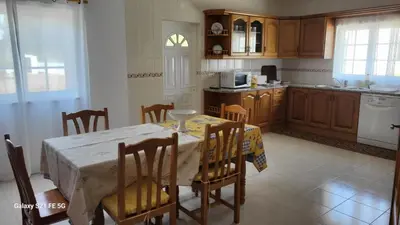 a kitchen with a table and some chairs and a kitchen with a table at Casa Estêvão in Aljezur
