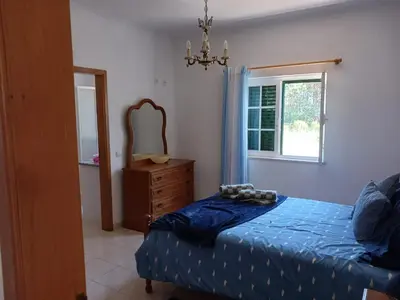a bedroom with a bed and a dresser and a mirror at Casa Estêvão in Aljezur