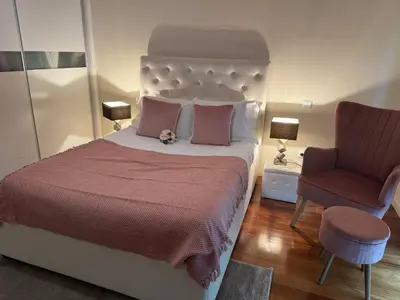 a bedroom with a large bed and a chair at Casared in Funchal