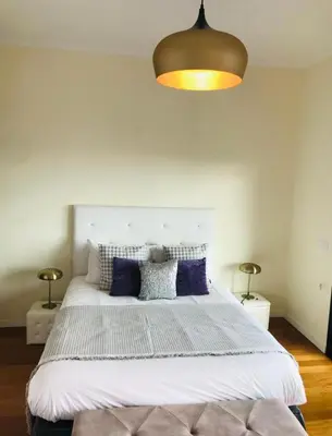 a bedroom with a large white bed with blue pillows at Casared in Funchal