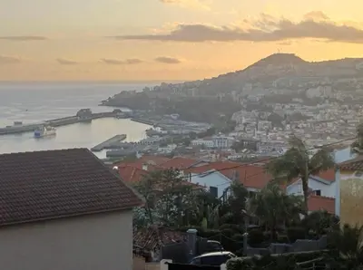 a view of a city and the ocean at sunset at Casared in Funchal