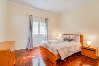 a bedroom with a bed and a dresser and a window at Cantinho da Portada in Seixal