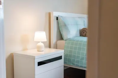 a bedroom with a bed and a table with a lamp at Cantinho da Portada in Seixal