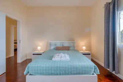 a bedroom with a bed with two night stands at Cantinho da Portada in Seixal