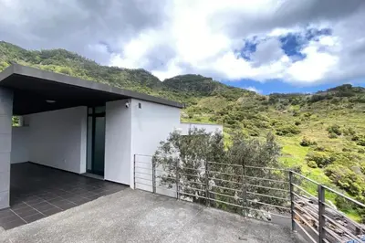 a house with a balcony with mountains in the background at Sal e Pimenta House - A Wellbeing Retreat in Machico
