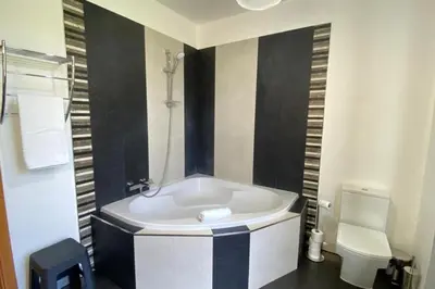 a bathroom with a white tub and a toilet at Sal e Pimenta House - A Wellbeing Retreat in Machico
