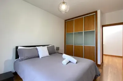 a bedroom with a large white bed with a wooden cabinet at Sal e Pimenta House - A Wellbeing Retreat in Machico