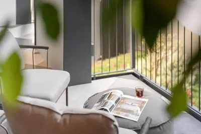 a living room with a table and a magazine and a chair at Savoy Insular II by An Island Apart in Funchal