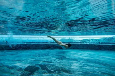 a person swimming in a pool in the water at Savoy Insular II by An Island Apart in Funchal